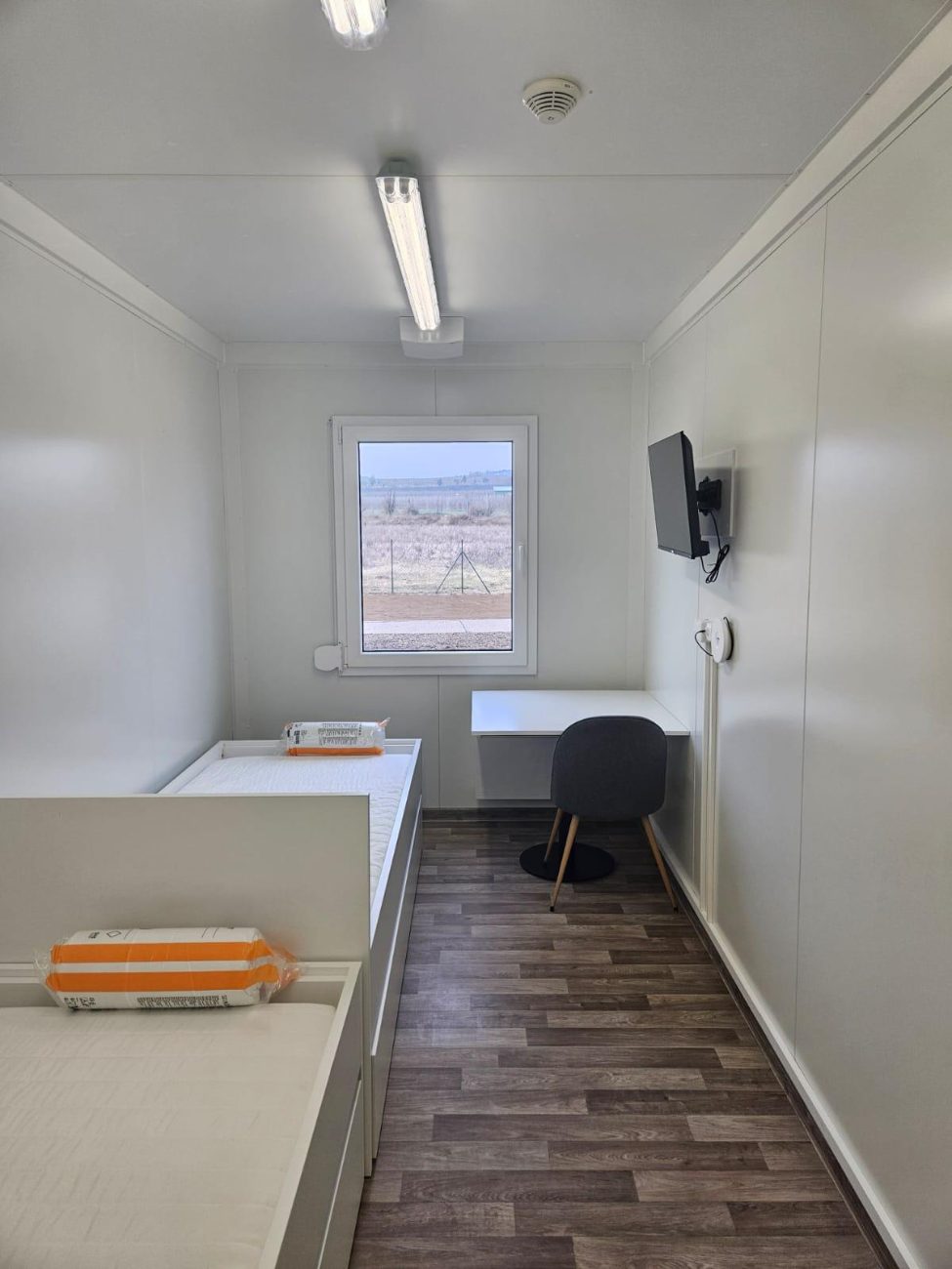 Möbliertes Zimmer mit Bett, Schreibtisch und Fernseher
