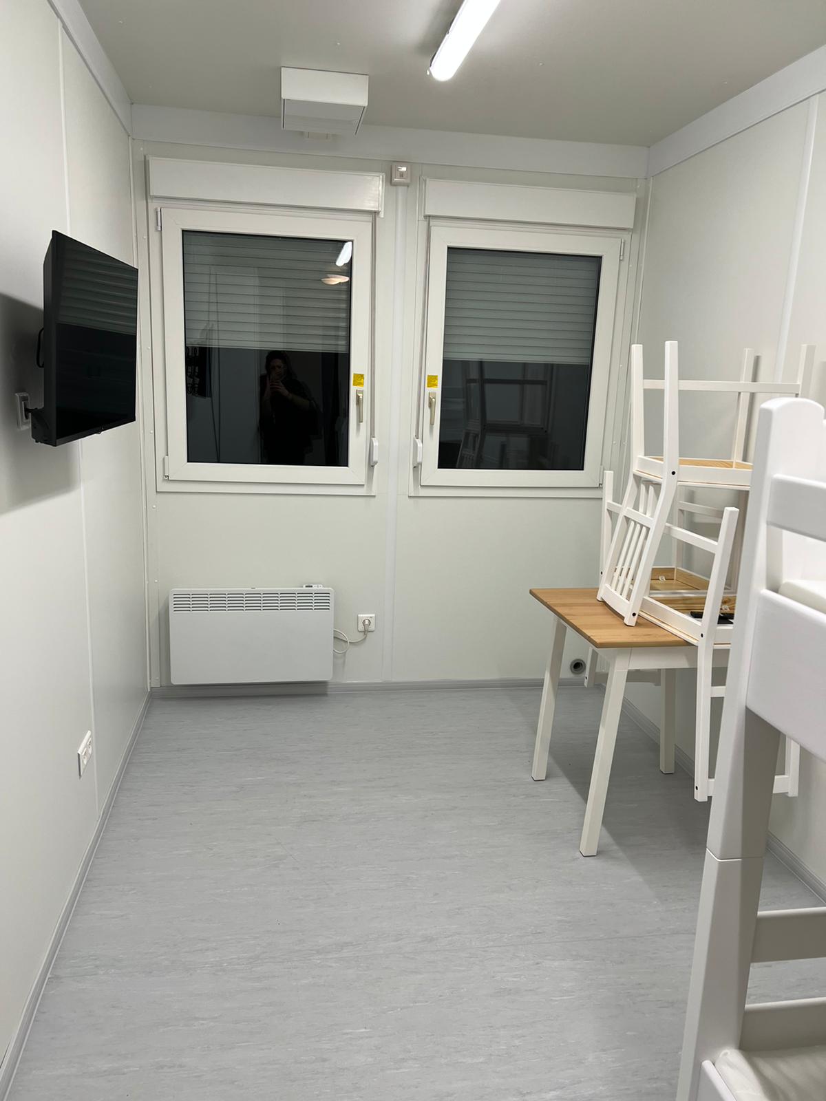 Zimmer mit Fernseher und Sitzgruppe